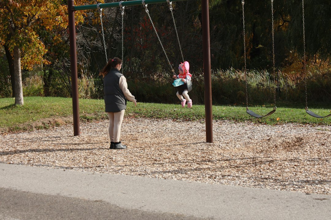 公園のブランコで遊ぶ子どもと見守る大人のイメージ画像（イメージ画像）
