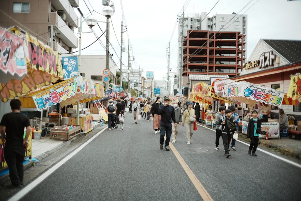 夏祭りの屋台が並ぶ通りのイメージ画像（Photo by Ashita Mata on Unsplash・実際のさかいふるさと祭りの写真ではありません）