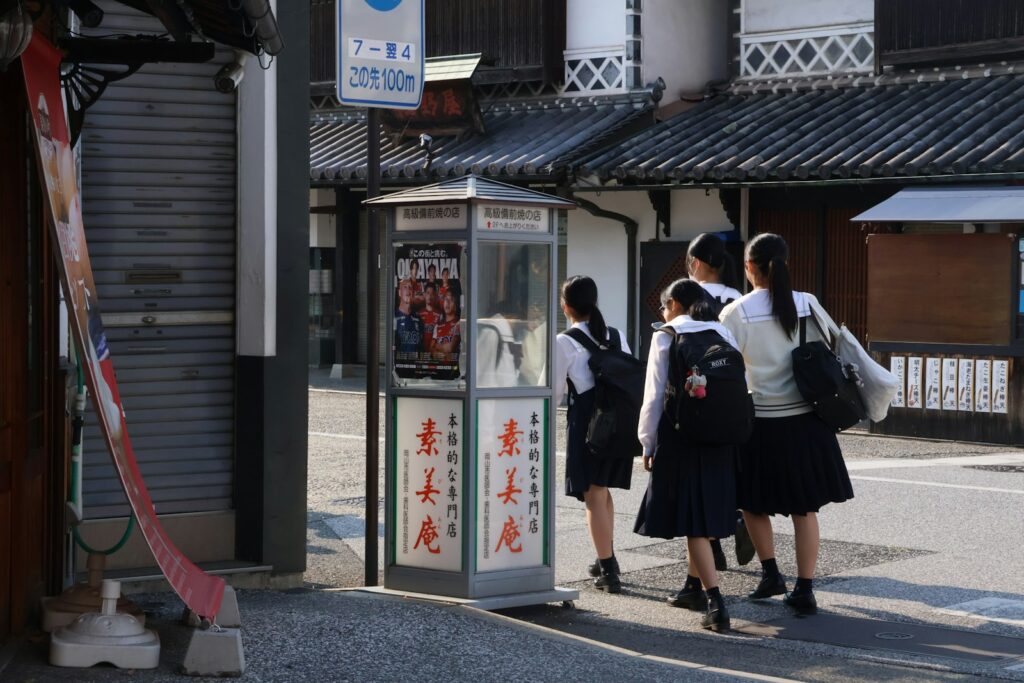 境町の高校進学ガイド2026のアイキャッチ（バス停の前を歩く日本の学生のイメージ画像。境町の実際の通学風景ではありません）